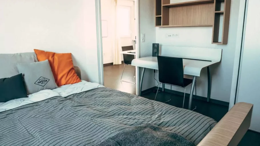 Chambre Chambre moderne avec un lit, un bureau et des murs clairs.