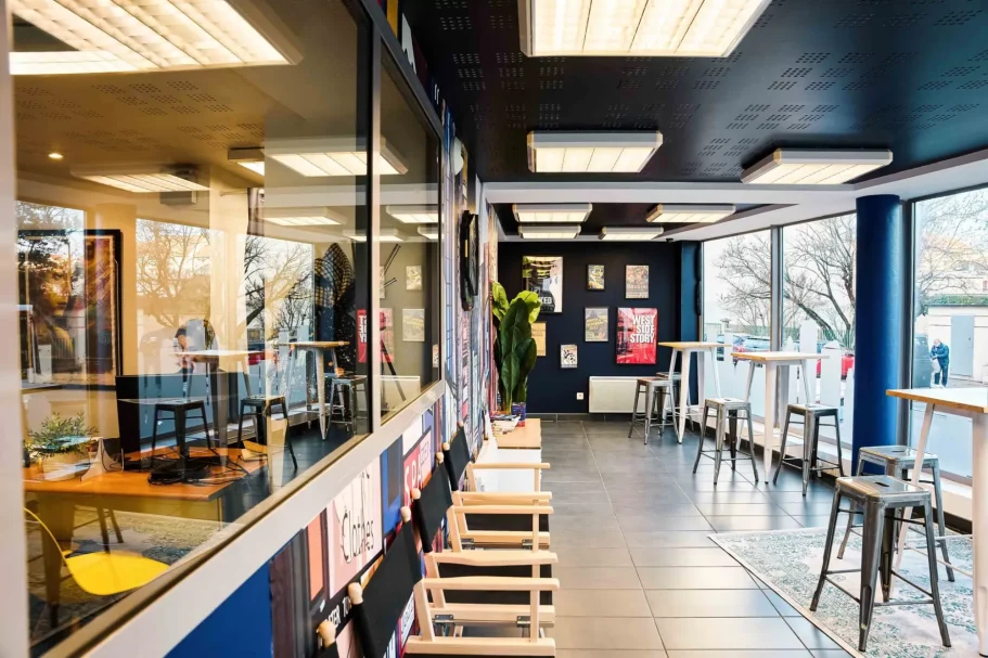 Coin bar Intérieur moderne d'un café, avec des tables, chaises et grandes fenêtres lumineuses.