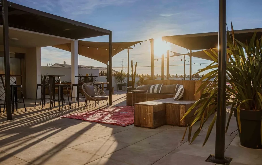 Terasse Terrasse moderne avec mobilier en bois, plantes et coucher de soleil.